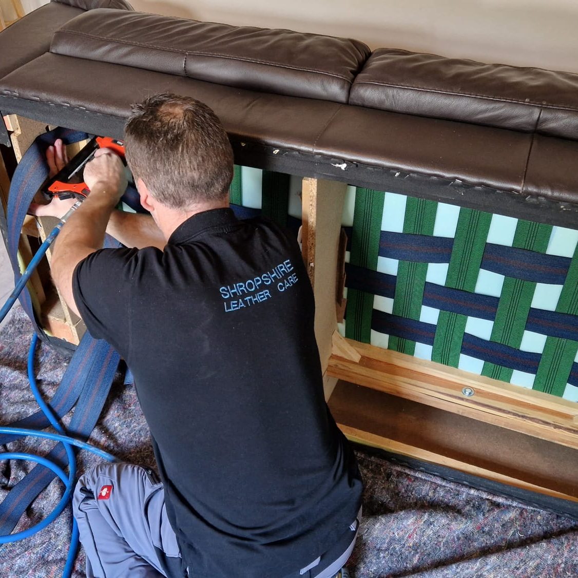 Installing new webbing straps under a sofa to restore seat support